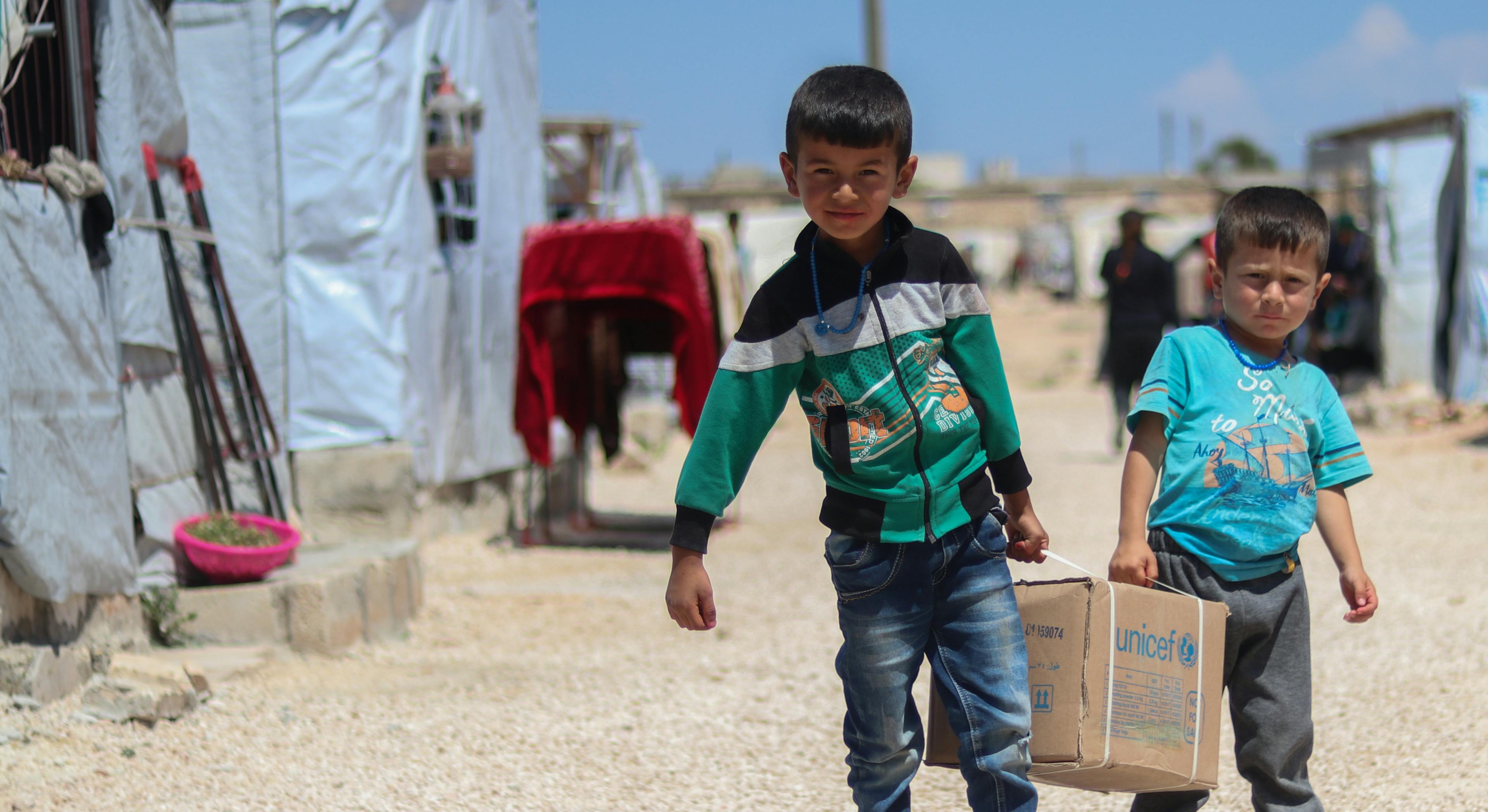Syrien 2020 - pojkar bär unicef paket