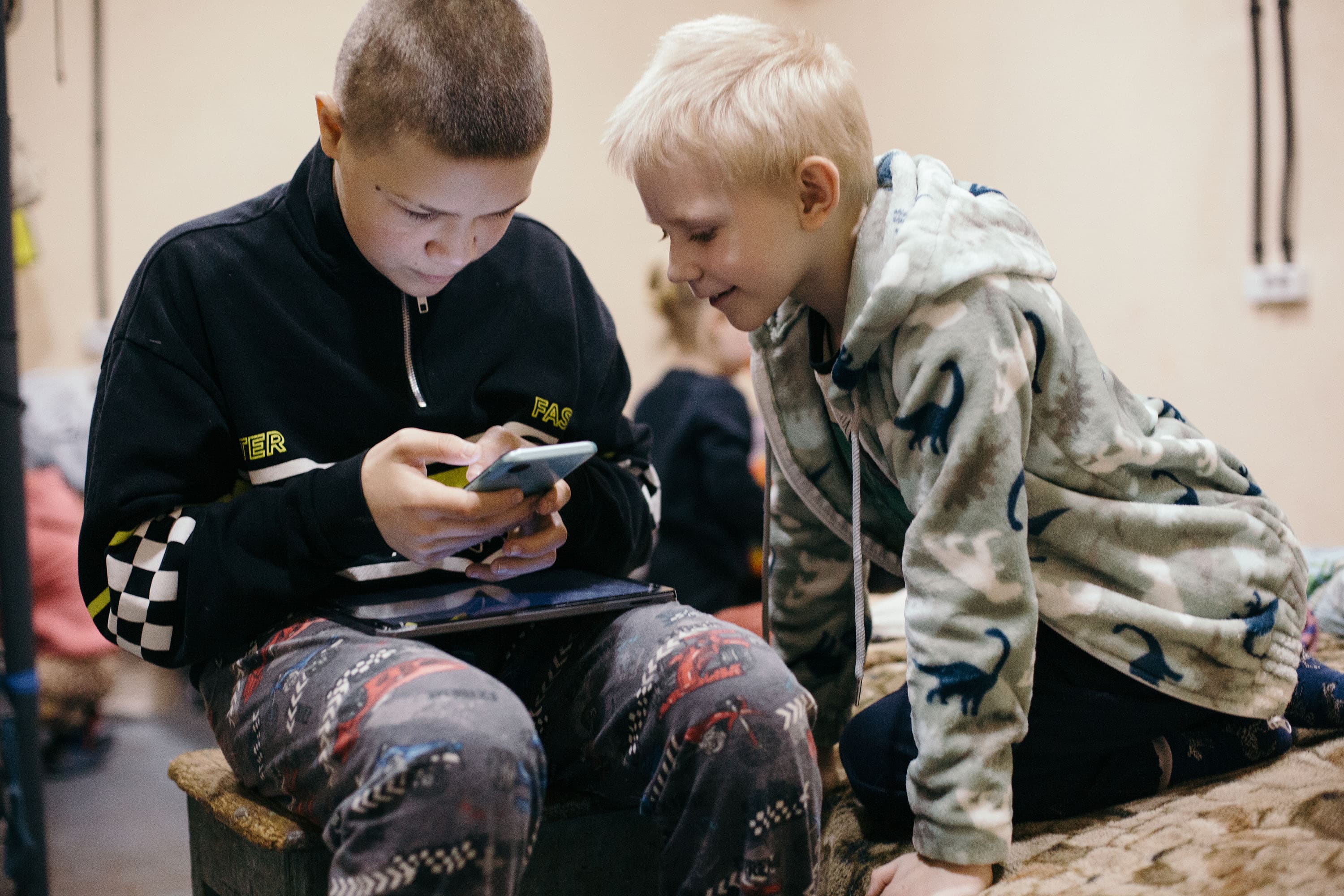 Pojkar som kollar i mobiltelefon – Ukraina 2026